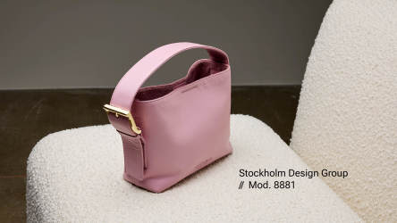 En rosa väska från Stockholm Design Group på en stol.