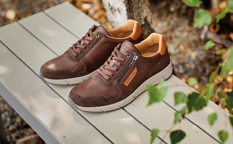 Brune fritidssko fra Softwalk med beige detaljer og glidelås på siden, plassert på en gr�å trebenk i naturomgivelser.