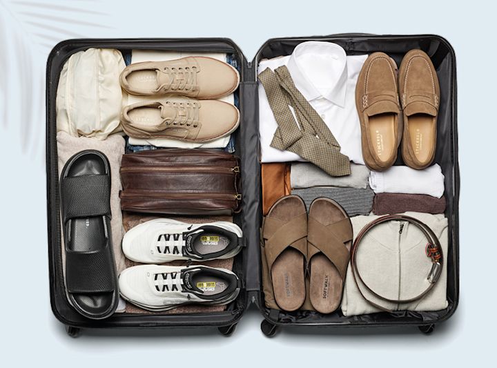 Åpen koffert med beige sneakers, hvite sneakers, brune loafers, brune sandaler og svarte slippers, samt klær og tilbehør.
