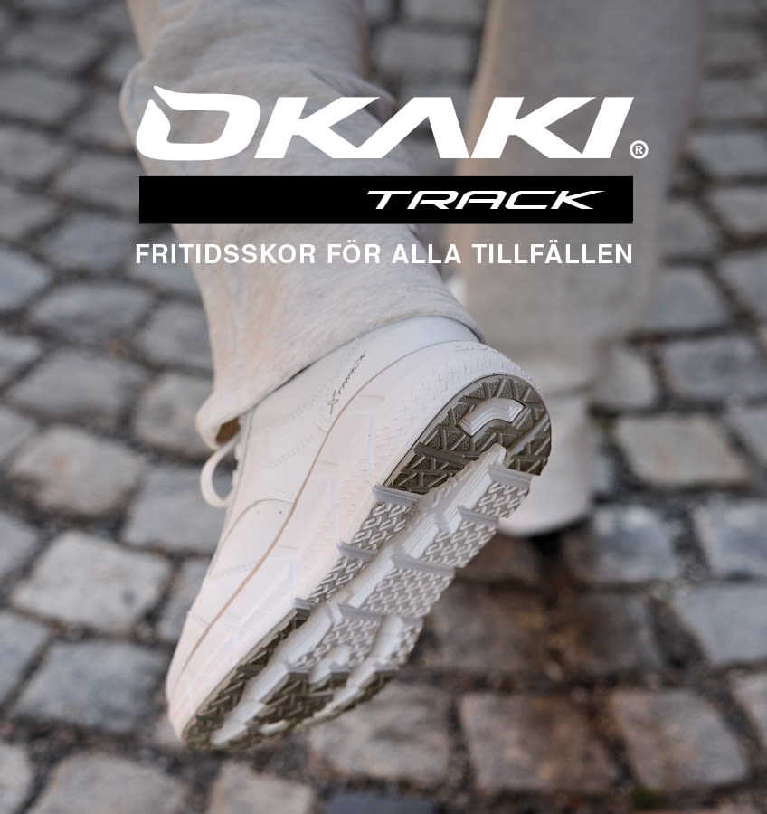 Vita OKAKI Track fritidsskor med mönstrad sula på stenbelagd gata, med logotyp och texten "Fritidsskor för alla tillfällen".