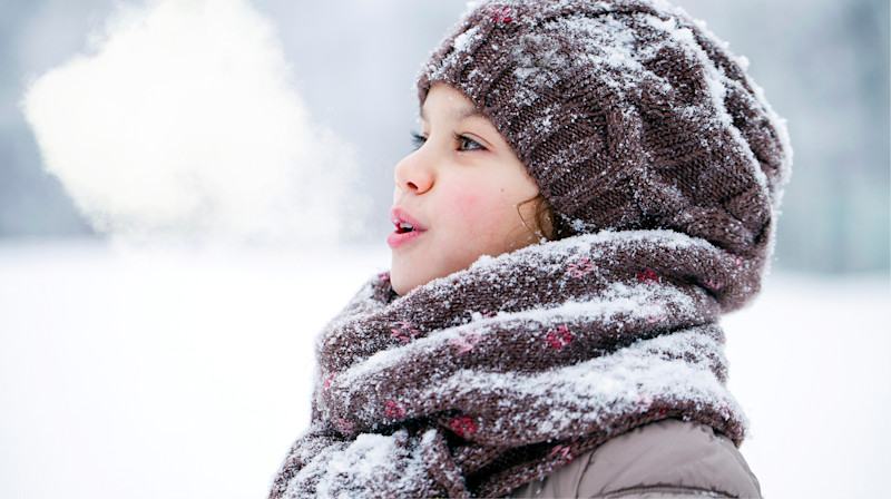 Barn ute på vinteren med snø.