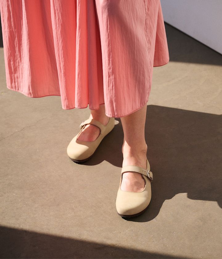 Kremfargede Mary Jane-sko med spenne og mørk såle fra Birkenstock, stylet med en rosa midi-kjole.