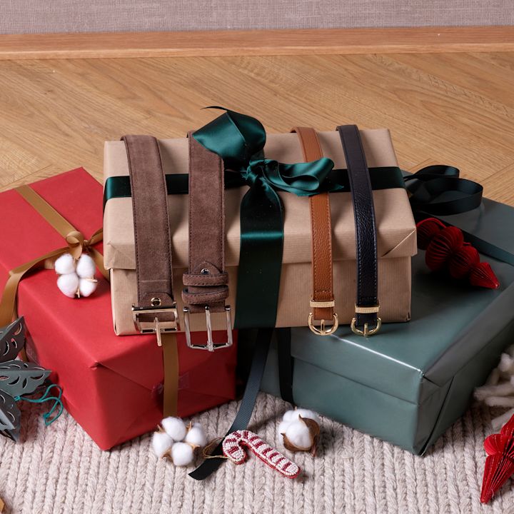 Presentförpackningar i rött, beige och grönt med läderbälten i brunt och svart, dekorerade med grönt sidenband.