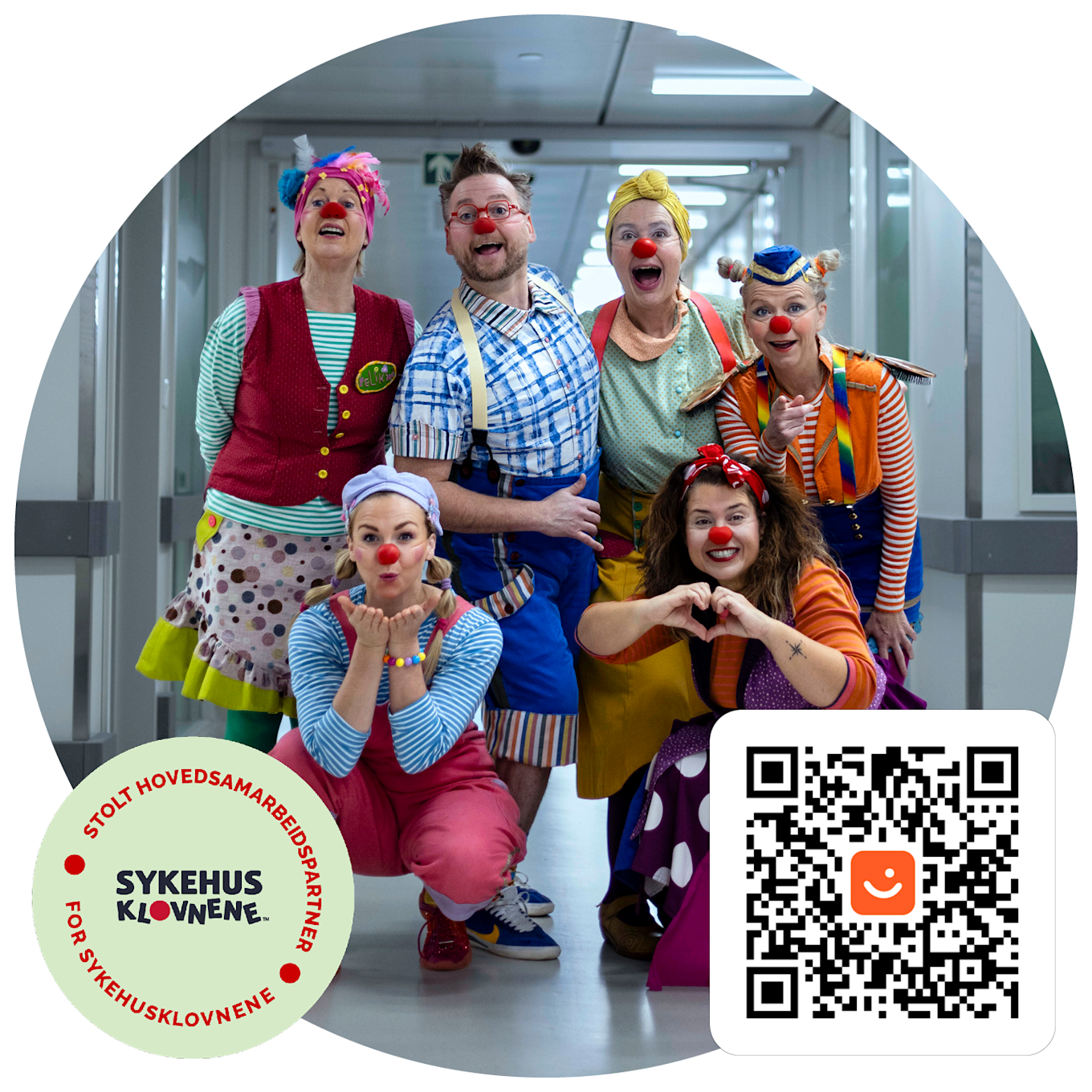 Gruppe med sykehusklovner i fargerike kostymer står i en sykehuskorridor, med logo og QR-kode synlig i hjørnene.
