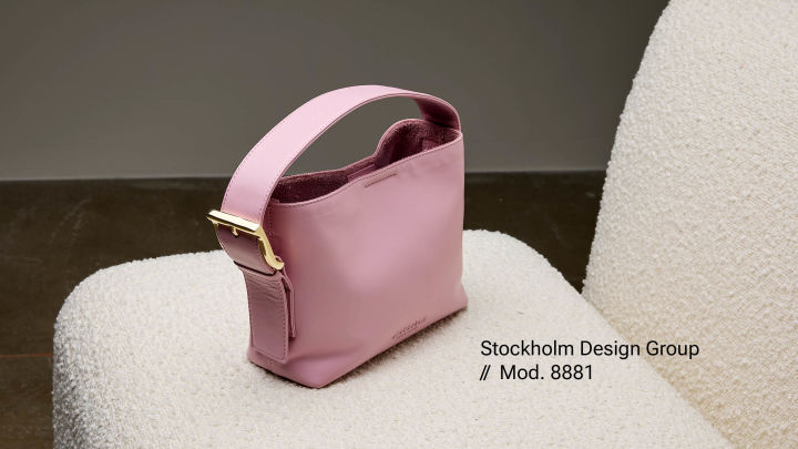 En rosa veske fra Stockholm Design Group på en stol.