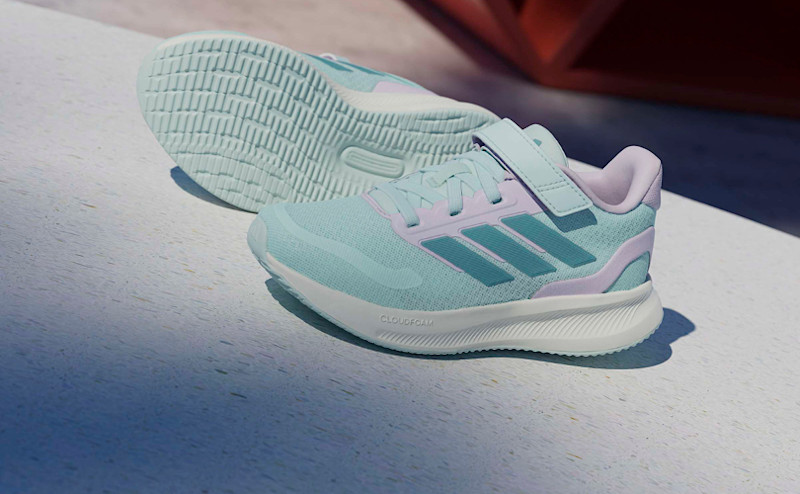 Mintgröna Adidas barnskor med kardborreband och rosa detaljer, placerade på vit yta.