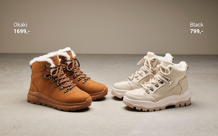 To par av vintersko med snøring og pelsfôr, en brun Okaki til 1699 kroner og en kremhvit Black til 799 kroner, plassert på et grått gulv mot en beige vegg.