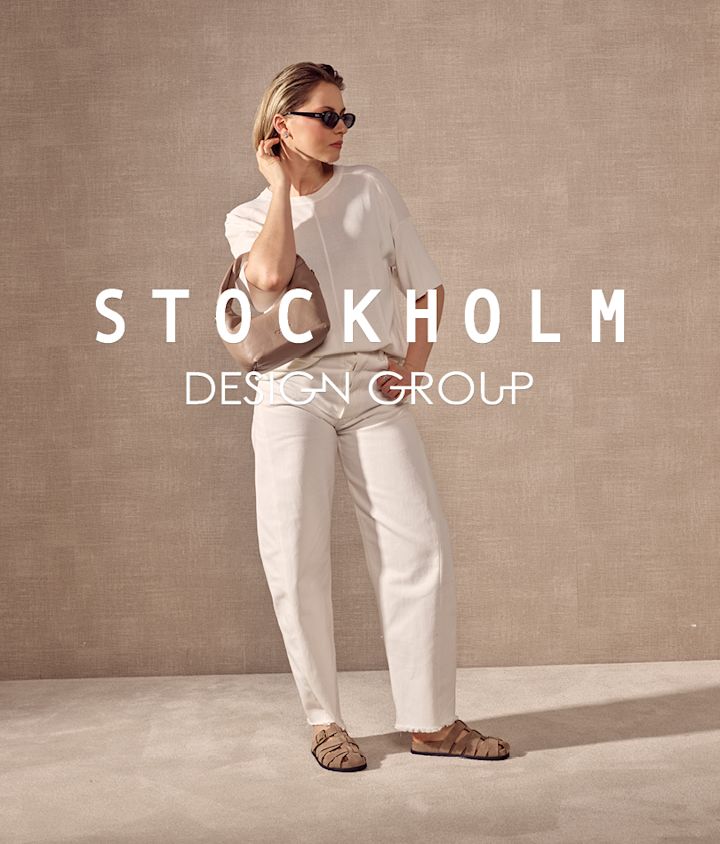 Kvinne i hvite bukser og topp med beige flate sandaler med stropper i retrostil.