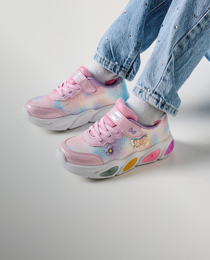 Rosa blinkskor med pastellfärgat mönster, fjärilsdetaljer och färgglada inslag på sulan, burna med jeans med paljetter.