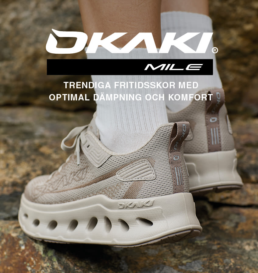 Beige OKAKI Mile fritidsskor med stickad ovandel, vit sula med ventilationshål och optimal dämpning, visas på stenig mark.