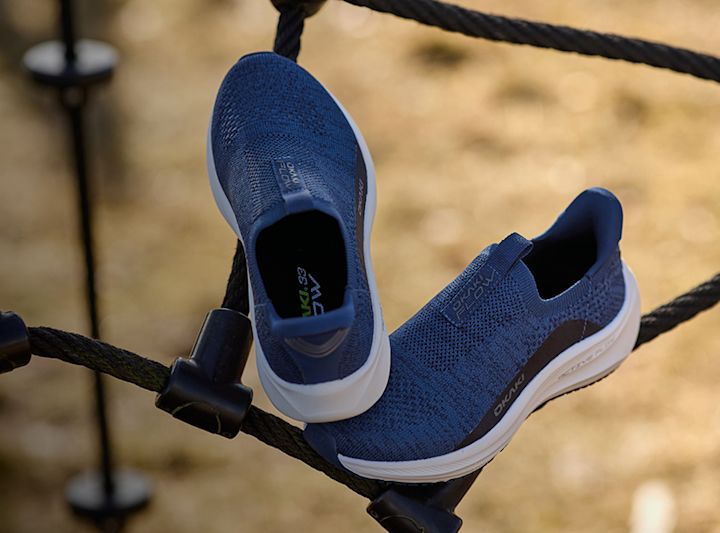 Blå sneakers fra Okaki med strikket overdel og hvit såle, plassert på tau utendørs.