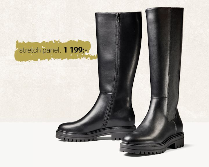 Svarta knähöga stövlar från Unified med stretchpanel och grov sula, pris 1 199 kr, visas mot ljus bakgrund.