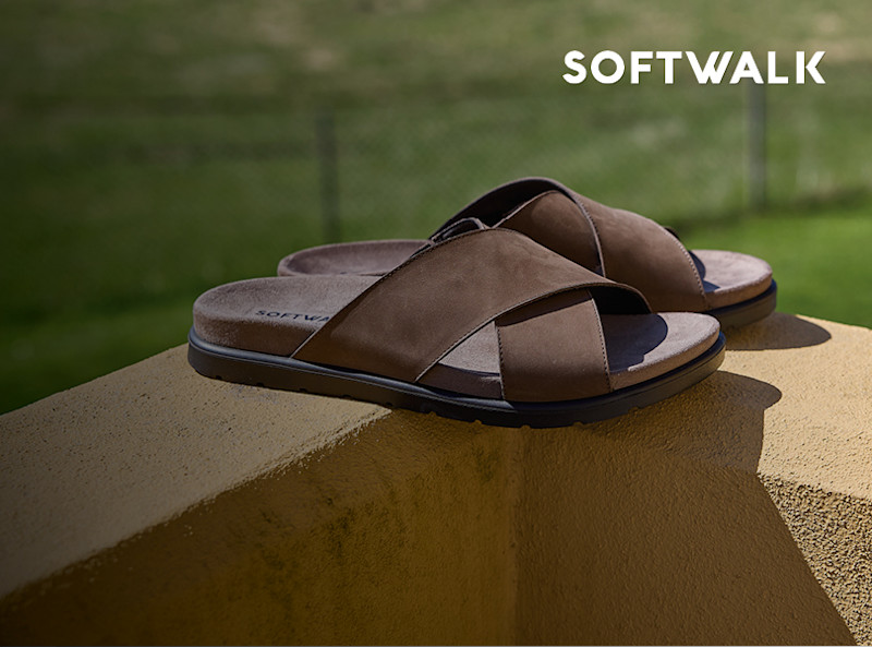 Brune sandaler med kryssede stropper fra Softwalk, plassert på en steinflate utendørs.