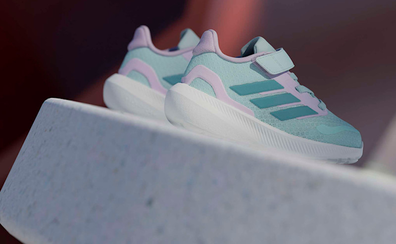 Mintgrønne og rosa barnesko fra Adidas med borrelås, plassert på en hvit overflate med sporty og moderne design.