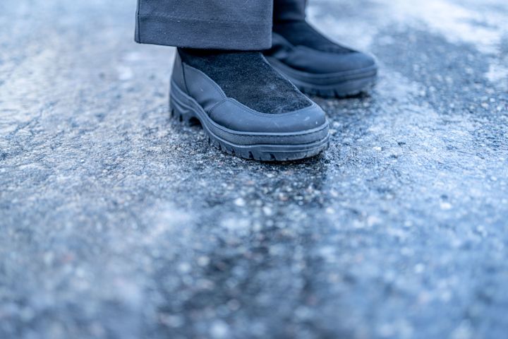 Svarta vinterskor med grovmönstrad sula som används på isiga och hala underlag utomhus.
