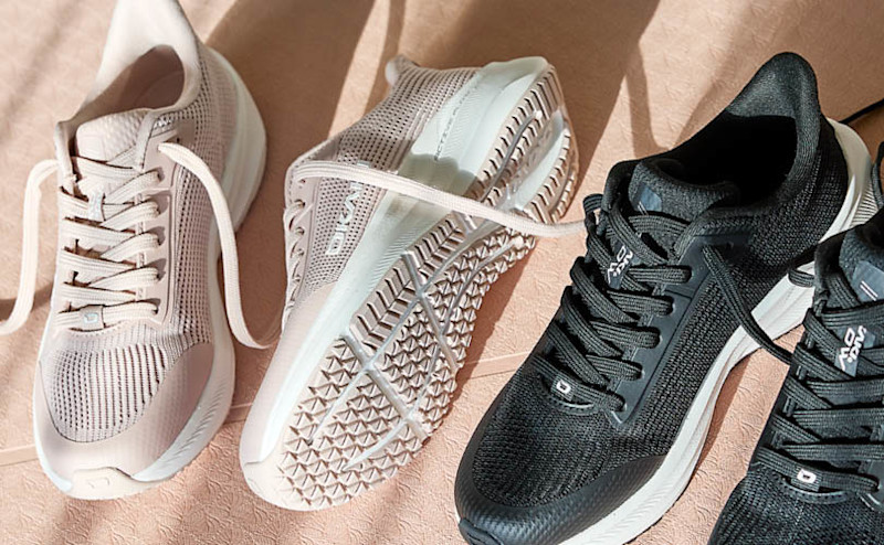 Tre sneakers: to rosa/beige og én svart, med hvite såler. En sko viser sålemønsteret. Moderne, sporty stil.