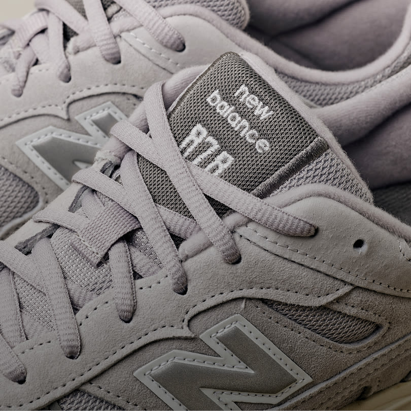Grå New Balance joggesko i semsket skinn og mesh med merkets karakteristiske N-logo på siden.