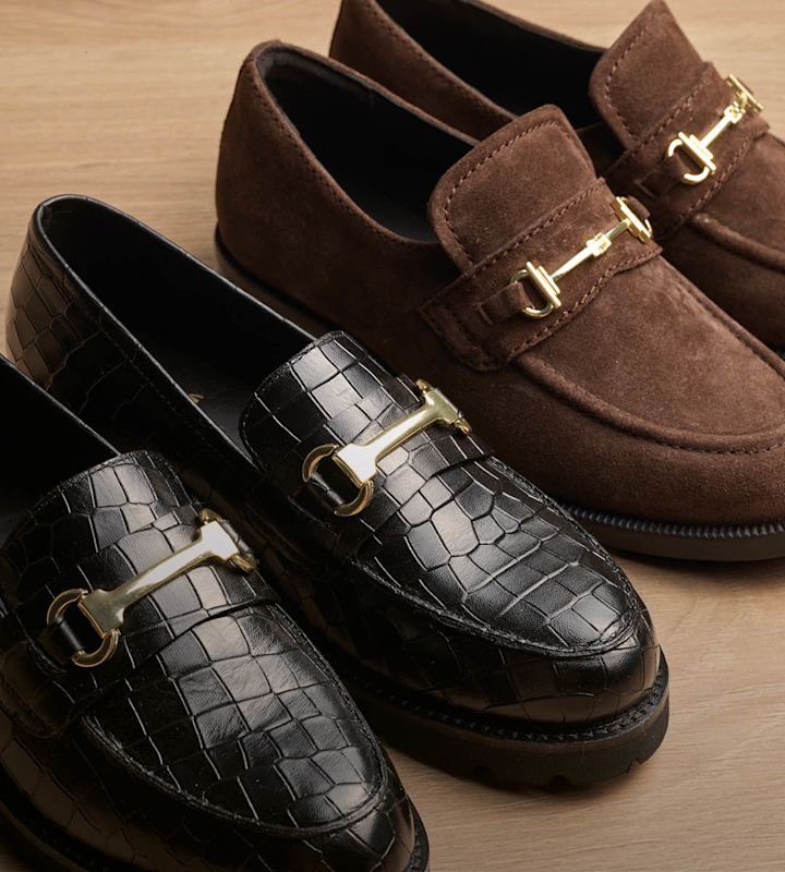 To elegante loafers: en svart med krokodillemønster og en brun semsket, begge med gull hestebit-detalj.