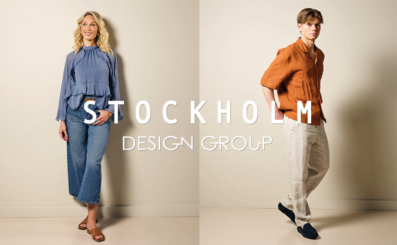 To personer i moteplagg med Stockholm Design Group-logo. Kvinne i blå bluse og brune sandaler, mann i oransje skjorte og mørkeblå loafers.