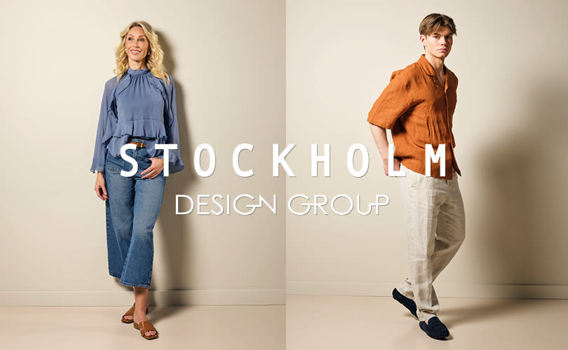 To personer i moteplagg med Stockholm Design Group-logo. Kvinne i blå bluse og brune sandaler, mann i oransje skjorte og mørkeblå loafers.