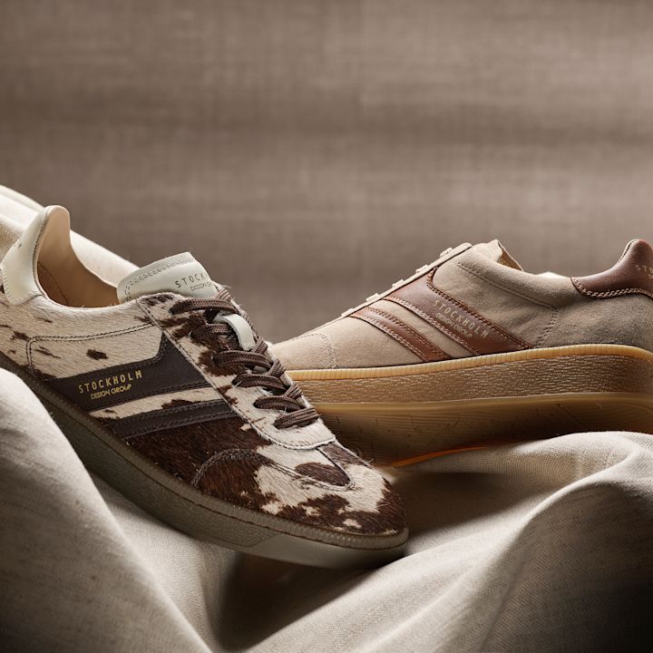 Två Stockholm-sneakers: en med kolädersmönster i brunt och vitt, och en i beige mocka med bruna detaljer, båda med gummisula.