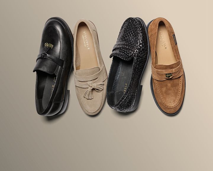 Fire elegante loafers i ulike stiler: svart skinn med spenne, beige med dusker, svart flettet skinn og brun semsket mokkasin.