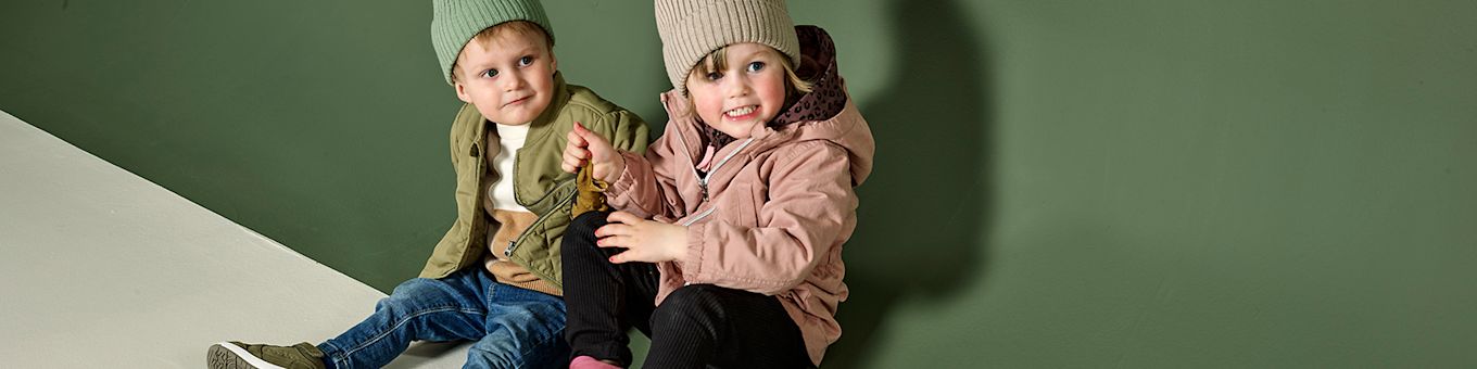 To små barn sitter på golvet.