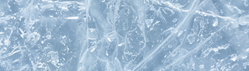 Nærbilde av blått islag med sprekker og luftbobler i isen.