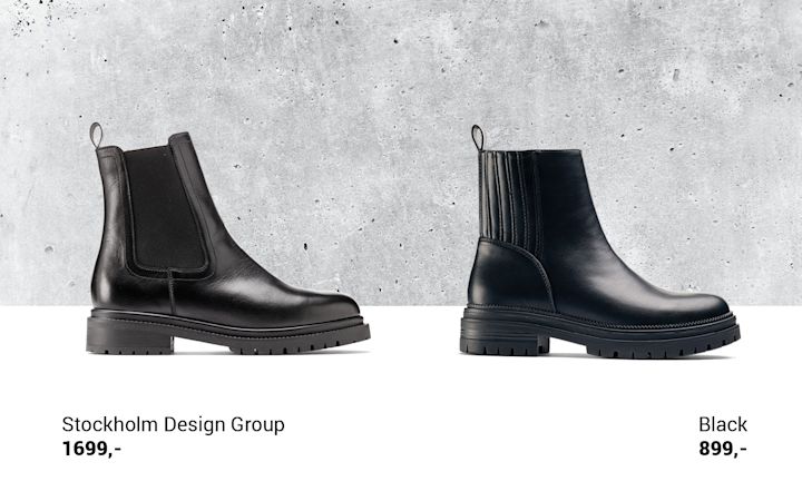 Två svarta skinnboots med grov sula, den vänstra från Stockholm Design Group prissatt till 1699 kr och den högra märkt Black prissatt till 899 kr, placerade framför en grå betongvägg.
