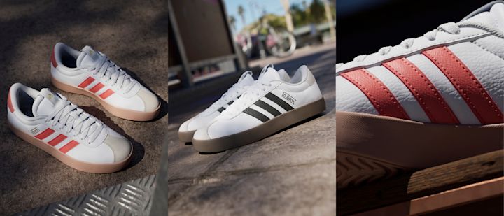 To par hvite Adidas-sneakers med henholdsvis røde og svarte striper, plassert på asfalt og i utendørs bymiljø.